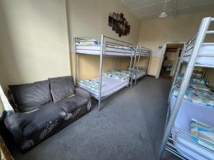 Habitación con 2 literas y sofá en Chalet Backpackers en Dunedin