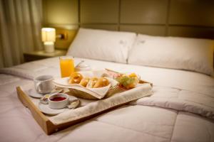 ein Tablett mit Speisen und Getränken auf dem Bett in der Unterkunft Hotel Convencion in Trujillo