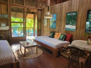 een woonkamer met een bed en een tafel bij Villa de el bosque in Puntarenas