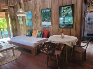 een slaapkamer met een bed en een tafel en stoelen bij Villa de el bosque in Puntarenas
