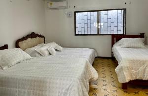 um quarto com 2 camas e uma janela em La Casa de Tía Ana em Ríohacha