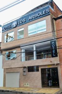 a building with a sign on the side of it at CASA HOTEL LOS ARBOLES in Bello