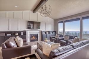 Una sala de estar con muebles de cuero y chimenea. en Oceanview Oasis, en Depoe Bay