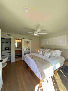 a bedroom with a bed and a ceiling fan at Location, location, location! 10 steps to the beach in San Diego
