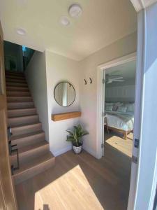 a room with a staircase and a bed and a mirror at Location, location, location! 10 steps to the beach in San Diego