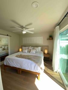 a bedroom with a bed with a ceiling fan at Location, location, location! 10 steps to the beach in San Diego
