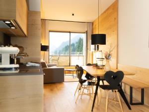 cocina y sala de estar con mesa y sillas en My Heimat 1495 Arlberg, en Schröcken