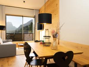 - une salle à manger avec une table et des chaises en bois dans l'établissement My Heimat 1495 Arlberg, à Schröcken