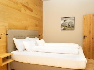 2 camas con almohadas blancas en una habitación en My Heimat 1495 Arlberg, en Schröcken