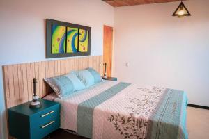sypialnia z łóżkiem z niebieską szafką nocną i obrazem w obiekcie Amplio duplex con terraza privada. w mieście Medellín