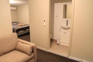 a room with a couch and a sink and a bed at Ivanhoe Hotel Motel in Ivanhoe