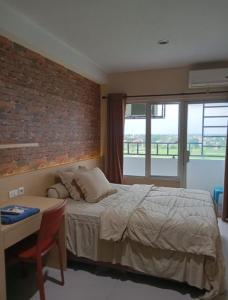 a bedroom with a bed and a brick wall at Niar P in Sunggal