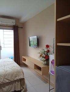 a bedroom with a bed and a tv on the wall at Niar P in Sunggal