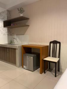 a kitchen with a sink and a table and a chair at Niar P in Sunggal