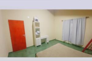 Zimmer mit roter Tür und grünem Boden in der Unterkunft el quincho in Mercedes