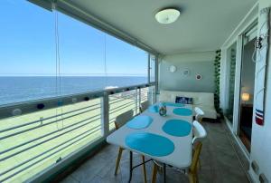 comedor con mesa y balcón con vistas al océano en El Encanto de Reñaca viña del mar, Excelente vista al mar bajada directa a la playa, en Viña del Mar