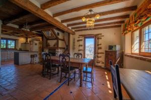 eine Küche und ein Esszimmer mit einem Holztisch und Stühlen in der Unterkunft Cortijo Los Arbolitos, alojamiento turístico rural in Güéjar-Sierra