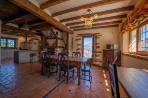 a kitchen and dining room with a wooden table and chairs at Los Arbolitos Shared Housing in Güéjar-Sierra