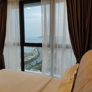 URBAN SUITES JSW STUDIO 3 ROOMS COMMERCIAL CONDO في Jelutong: غرفة نوم مع نافذة مطلة على المحيط