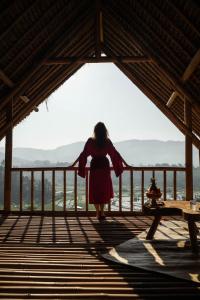 Eine Frau, die auf einer Holzterrasse mit Meerblick steht in der Unterkunft Sandag Hill in Sidemen