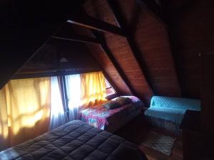 um quarto no sótão com 2 camas e uma janela em Casa en Liquiñe em Liquiñe