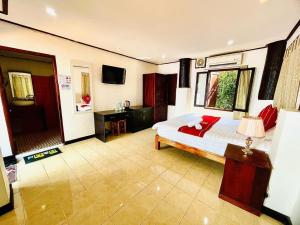 a bedroom with a bed and a television in it at Vieng Savanh II Hotel in Luang Prabang