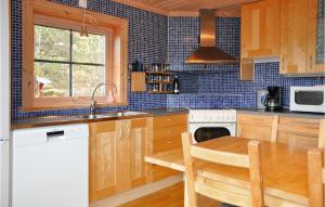 a kitchen with wooden cabinets and a table and a sink at Lovely Apartment In Slen With House A Panoramic View in Sälen
