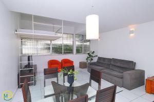 uma sala de estar com um sofá e uma mesa de vidro em Apartamento 2 quartos espaçoso no Leme no Rio de Janeiro