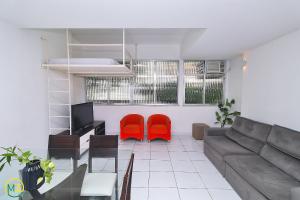 een woonkamer met een bank en 2 rode stoelen bij Apartamento 2 quartos espaçoso no Leme in Rio de Janeiro