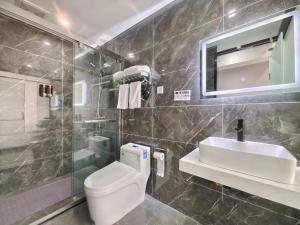 a bathroom with a toilet and a sink and a shower at Xian Feng Hotel - Tianfu International Airport Branch in Jianyang