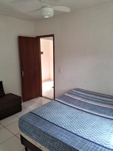 a bedroom with a bed with a blue comforter at Vivamar in Cabo Frio +11 photos