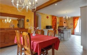 une cuisine et une salle à manger avec une table et des chaises rouges dans l'établissement Stunning Home In Amailloux With Outdoor Swimming Pool, à Amailloux