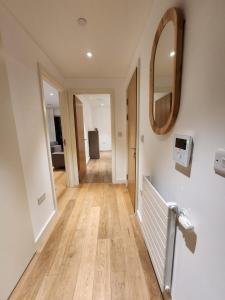 um corredor de uma casa com um espelho e pisos de madeira em The maud luxury garden em Londres