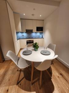 a white dining room table and chairs in a kitchen at The maud luxury garden in London