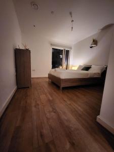 a large bedroom with a bed and a wooden floor at The maud luxury garden in London