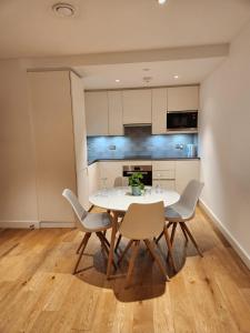 a dining room with a white table and chairs at The maud luxury garden in London