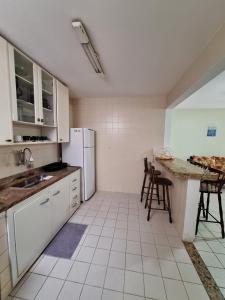 uma cozinha com um frigorífico, uma mesa e cadeiras em Apartamento Praia do Forte - Centro em Cabo Frio