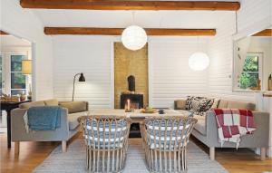 - un salon avec une table, des chaises et une cheminée dans l'établissement Stunning Home In Rrvig With Wifi, à Rørvig