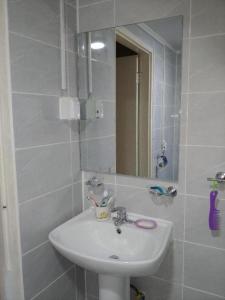 La salle de bains blanche est pourvue d'un lavabo et d'un miroir. dans l'établissement Good Stay Itaewon, à Séoul