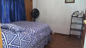 1 dormitorio con 1 cama con edredón azul y blanco en Cabaña Los Ángeles, en Huasca de Ocampo