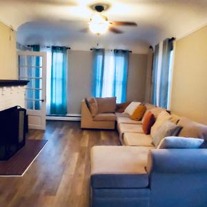 a living room with a couch and a tv at Rustic Colonial Home with Private Rooms in Waterbury