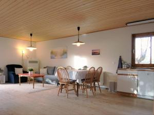 a living room with a table and chairs and a couch at Ferienhaus Eggert - Gemütliches Holzhaus mit skandinavischem Flair in Lindewitt