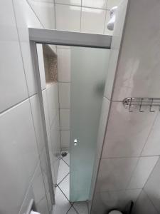 a shower with a glass door in a bathroom at Quarto Laurinda 3 in Guararema