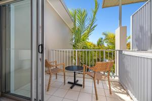 eine Terrasse mit Stühlen und einem Tisch auf dem Balkon in der Unterkunft Bells Blvd Resort & Spa Apartments - Holiday Management in Kingscliff