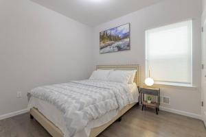 a white bedroom with a bed and a window at Beautiful 3bedroom apartment in Elizabeth