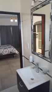 Un baño con lavabo, espejo y cama. en Solar de Artalaz, en Colón