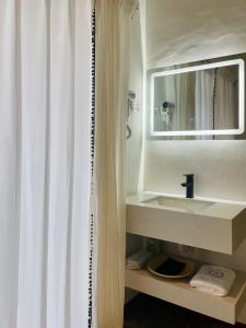 a bathroom with a sink and a mirror at Attitude Resort Langkawi in Pantai Cenang