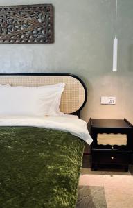 珍南海滩Attitude Resort Langkawi的一间卧室配有一张带绿毯的床和床头柜。