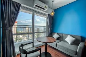 a living room with a couch and a large window at TK Nha Trang Hotel in Nha Trang