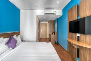 a bedroom with a bed and a flat screen tv at TK Nha Trang Hotel in Nha Trang